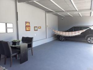 ein Auto, das in einer Garage mit Hängematte parkt in der Unterkunft Linda edícula a 80 m da Praia de Itapuã in Salvador