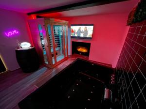 a room with a fireplace and a tv on the wall at ZEN & SPA in Givet