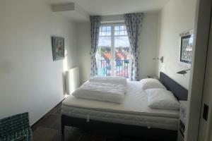 - une chambre avec un lit doté de draps blancs et une fenêtre dans l'établissement Villa Duindoorn 2.302, à Cadzand