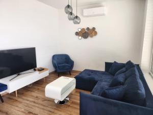 a living room with a blue couch and a tv at Meridiem byt in Topoľčany