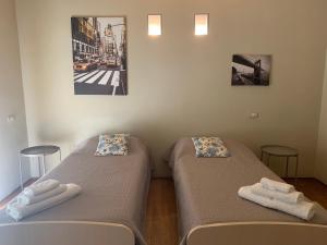 two beds in a room with towels on them at Greige Apartment in La Spezia