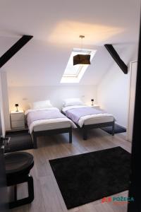 two beds in a room with a skylight at Apartment Eden in Požega