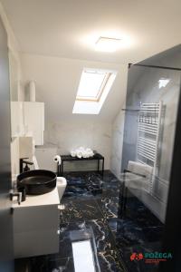 a bathroom with a toilet and a sink and a window at Apartment Eden in Požega