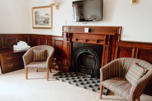a living room with two chairs and a fireplace at Royal Hotel in Stornoway