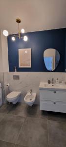 a bathroom with two sinks and a toilet and a mirror at Apartament Baltic Sea Gate Porta Mare 55m2 in Dziwnówek