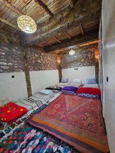 a room with three beds in a room with a rug at Authentic Moroccan Family Homestay 