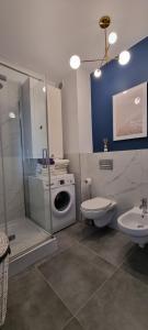 a bathroom with a washing machine and a toilet at Apartament Baltic Sea Gate Porta Mare 55m2 in Dziwnówek