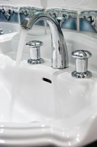 a bathroom sink with water running from a faucet at Logis Hotel-Restaurant Dimmer in Wallendorf pont