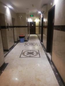 a hallway with a tile floor in a building at مبني الششة 5 in Al Khansāk