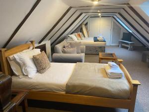 a attic room with two beds and a couch at Dyke Farm Barn near Brighton by Huluki Sussex Stays in Brighton & Hove