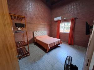 una camera con letto e finestra con tende rosse di LA RANCHADA a Paso de la Patria