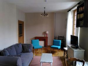 uma sala de estar com um sofá e duas cadeiras azuis em Gîte 5 pers en Périgord em Siorac-en-Périgord