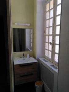 uma casa de banho com um lavatório e um espelho em Gîte 5 pers en Périgord em Siorac-en-Périgord