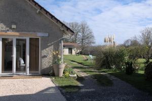 a stone house with a window and a yard at Le Cocon des Layes classé officiellement 5 étoiles in Les Essarts-le-Roi