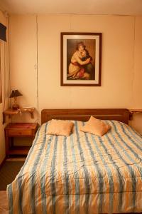 Coñaripe alojamiento في بانغويبولي: غرفة نوم بسرير مع لوحة على الحائط
