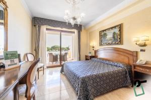 a hotel room with a bed and a desk and a desk at Hotiday Olbia Porto in Olbia