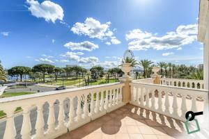 a balcony with a white railing with a view of a park at Hotiday Olbia Porto in Olbia