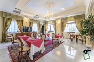 a dining room with tables and chairs and a television at Hotiday Olbia Porto in Olbia