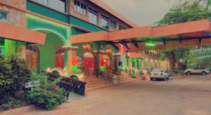 ein grünes Gebäude mit Treppen und Autos vor dem Haus in der Unterkunft Dodoma Rock Hotel Ltd in Dodoma