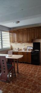 - une cuisine avec des placards en bois, une table et une cuisinière dans l'établissement Yuka family home, à Sarajevo