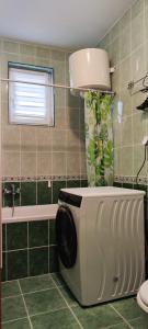 - un lave-linge dans la salle de bains pourvue d'une fenêtre dans l'établissement Yuka family home, à Sarajevo
