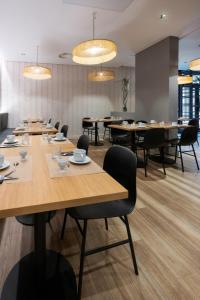 a conference room with tables and chairs and chandeliers at Nemea Appart Hotel Le Lido Cagnes sur Mer in Cagnes-sur-Mer