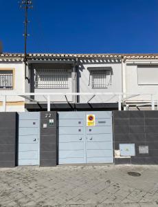 a white building with two garage doors on a street at H&H Casa en centro de Granada in Granada