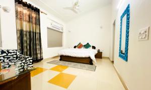 - une chambre avec un lit et un canapé dans l'établissement The Basera, à Rishikesh