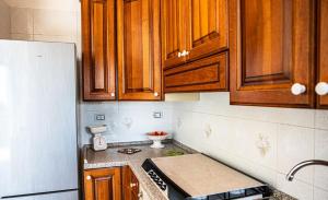 a kitchen with wooden cabinets and a counter top at La Casa del Panza con vista mare in Isola del Giglio +4 photos
