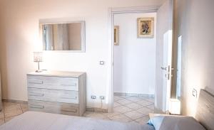 a bedroom with a bed and a dresser and a mirror at La Casa del Panza con vista mare in Isola del Giglio