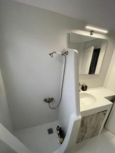 a white bathroom with a sink and a mirror at Summer House in Porto Heli