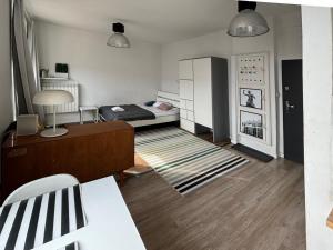 um pequeno quarto com uma cama e uma mesa em Apartament przy Rotundzie em Varsóvia