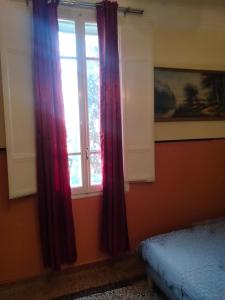 una camera da letto con tende rosse e una finestra di SANT'ORSOLA PALACE AND SUITE a Bologna