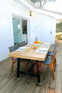 a wooden table on a deck with a bowl of fruit at Chalet Californien, piscine privée, plage 5 mn ! in Gassin
