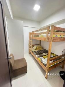 een kamer met 2 stapelbedden en een stoel bij The Burnham Hill Condo by Jobix in Baguio