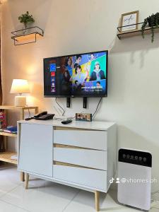 una TV a schermo piatto sopra un comò bianco di The Burnham Hill Condo by Jobix a Baguio