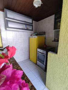 uma cozinha com um frigorífico amarelo e um fogão em Casa 3/4 Guarajuba BA em Camaçari