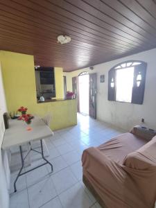 um quarto com uma cama e uma mesa com flores em Casa 3/4 Guarajuba BA em Camaçari