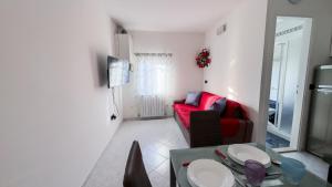a living room with a red couch and a table at Casa Raffi by Ca-Sa Check in Chioggia +26 photos