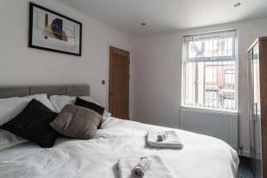 a bedroom with a white bed with towels on it at Harmony House: Shared Spaces Room 3 in Manchester
