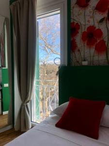 1 dormitorio con cama y ventana con vistas en DIMOR'A' ROOMS, en Pitigliano