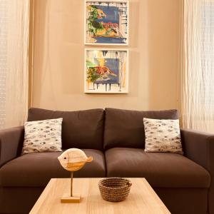 a living room with a brown couch and a table at Greige Apartment in La Spezia