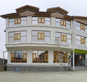 duży biały budynek z mnóstwem okien w obiekcie Hotel Gulmarg Residency, Kunzer Gulmarg w mieście Gulmarg