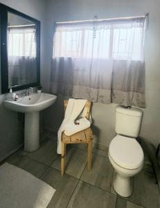 a bathroom with a toilet and a sink at OR Tambo Rudman B self-Catering Home L2 in Boksburg