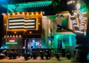a group of motorcycles parked outside of a building at night at SAN BEACH RESIDENCY in Karaikal