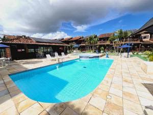uma grande piscina com água azul num resort em Chalé do Paraiso - Casa bem Equipada e Confortável para seu Lazer em Gravatá! em Gravatá