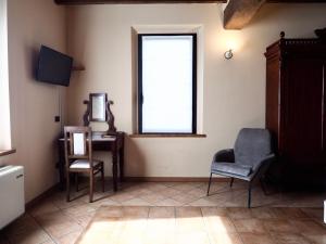 Habitación con ventana, escritorio y sillas. en Agriturismo San Giuseppe, en Gattatico
