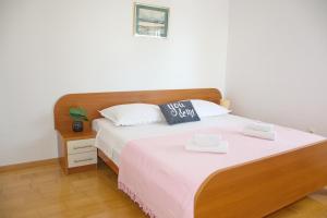 a bedroom with a large bed with a wooden headboard at Apartment MiraMar in Novalja