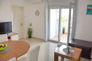 a living room with a table and a television at Apartment MiraMar in Novalja