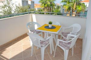 a table and chairs on the balcony of a apartment at Apartment MiraMar in Novalja